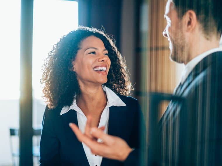 Coworkers laughing after managing workplace conflict with communication – Learn2