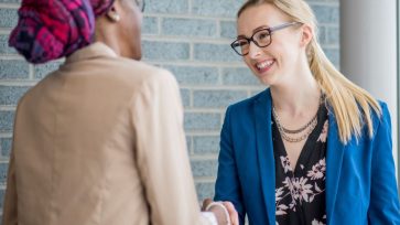 Two women shaking hands following an orientation